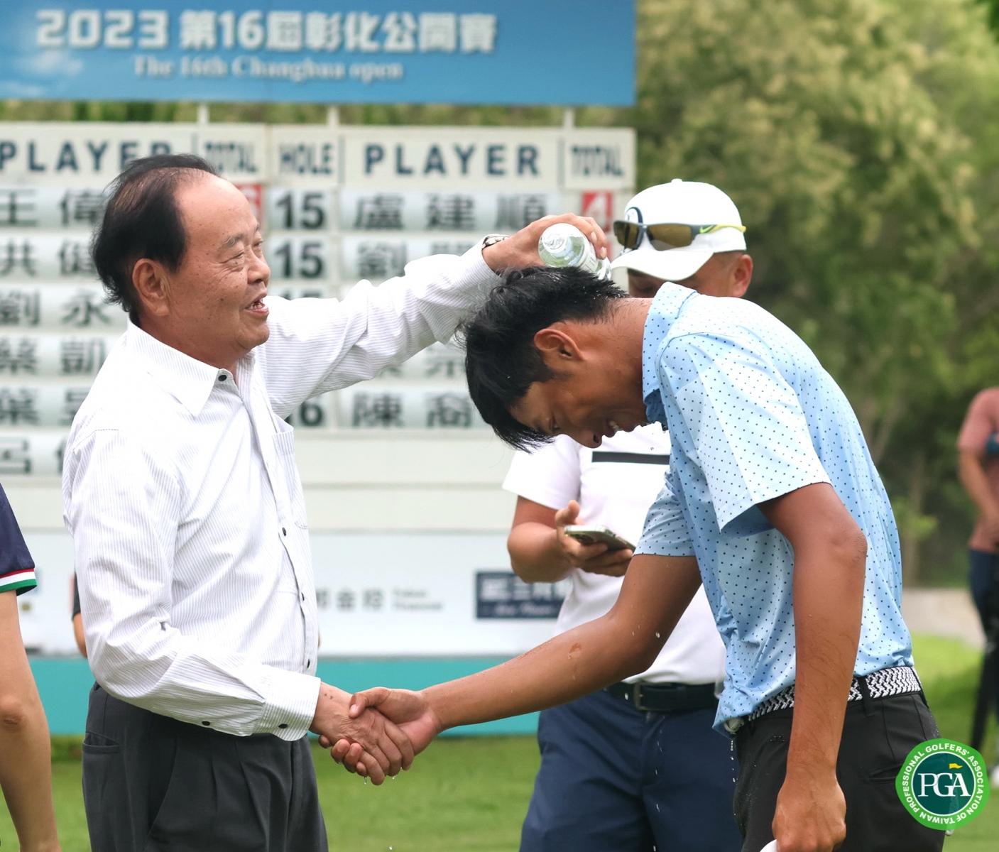 彰化球場董事長林賜農(左)為冠軍得主王偉軒澆水祝賀(鍾豐榮攝影)